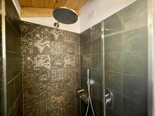 La salle de bains est pourvue d'une douche avec du carrelage noir. dans l'établissement CaVecchie Desenzano, à Desenzano del Garda