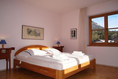 a bedroom with a large bed with a window at Ferienhaus-Eschenlohe-Direkt-in-Bergnaehe-Wanderungen-und-Mountainbike-vom-Haus-aus-moeglich in Eschenlohe