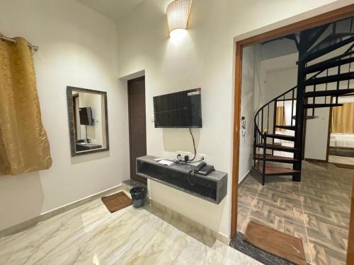 a room with a sink and a television on a wall at La Tamara Suite - TIE Hotels & Resorts in Puducherry