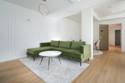 a living room with a green couch and a table at Adria Concept Suites in Zadar