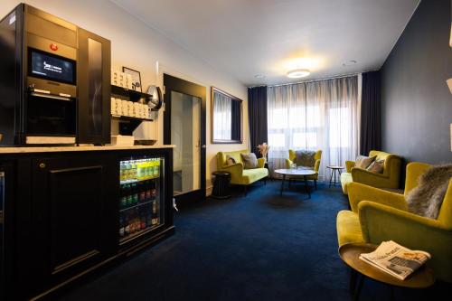 a hotel room with a waiting area with couches and a tv at Milling Hotel Ritz Aarhus City in Aarhus