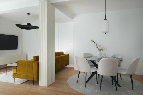 a dining room with a table and white chairs at Adria Concept Suites in Zadar