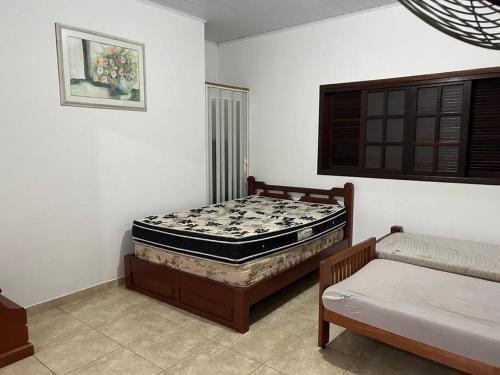 ein Schlafzimmer mit einer Matratze auf einem Bettrahmen und einer Couch in der Unterkunft Sítio Paraíbuna - Fazenda Paraíbuna - Casa Campo in Paraibuna