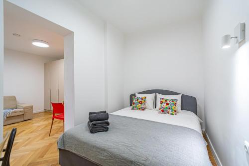 - une chambre avec un lit et une chaise rouge dans l'établissement Near Žalgiris Arena Apartment, à Kaunas