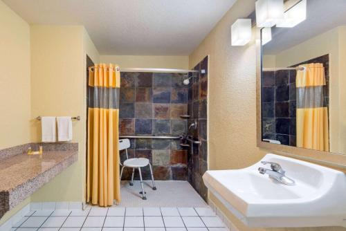 y baño con lavabo y ducha. en Days Inn by Wyndham Seaworld Lackland AFB, en San Antonio