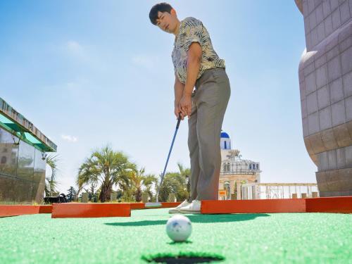 a man is playing a game of golf at GoldOne Hotel & Suites in Seogwipo