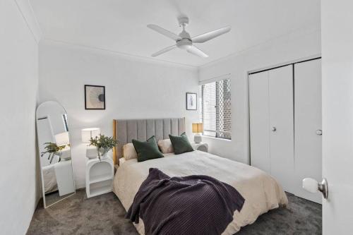 a white bedroom with a bed and a ceiling fan at 3br unit Stylish retreat SouthPerth in Perth