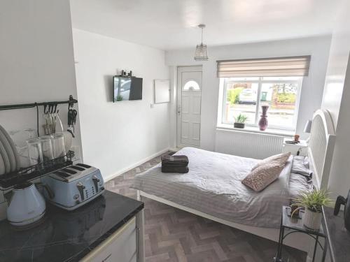 um pequeno quarto com uma cama e uma janela em Brand New Garage Conversion em Urmston