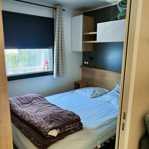 une petite chambre avec un lit et une fenêtre dans l'établissement Bungalow confortable à Vias avec piscine partagée, à Vias