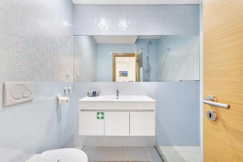 Baño blanco con lavabo y aseo en Garden Hill Relax & Old Town by OCvillas, en Albufeira