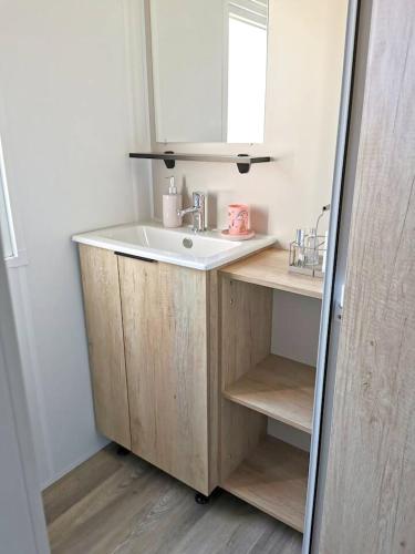 une salle de bain avec un lavabo et un miroir dans l'établissement Bungalow confortable à Vias avec piscine partagée, à Vias