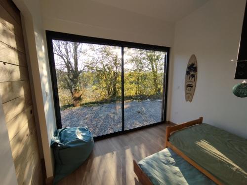 1 dormitorio con ventana grande con vistas al patio en Au calme, belles prestations, en Saint-Pierre-de-Chandieu