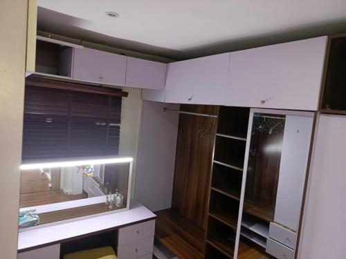 Habitación con armarios blancos, escritorio y ventana. en Lovely 2-Bed House in Lagos en Lagos