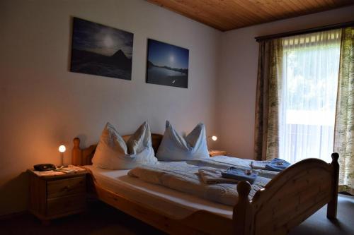 a bedroom with a bed with white sheets and pillows at Ferienhof Unterkotgraben in Spital am Pyhrn