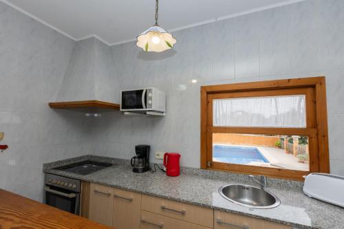 a small kitchen with a sink and a window at Yourhouse Villa Sa Caseta in Llubí
