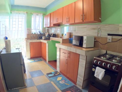 a kitchen with wooden cabinets and a stove at Nyeri Nest Retreat - One Bedroom in Nyeri