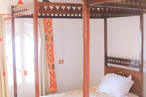 a bedroom with a bed with a wooden bed frame at Old Nubian guest house in Aswan