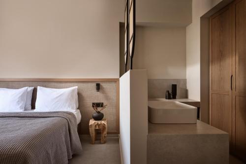 a bedroom with a bed and a bathtub and a sink at Alamis Hotel & Apartments in Tsilivi