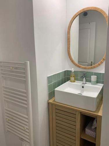 une salle de bain avec un lavabo blanc et un miroir dans l'établissement Boulouris - Appt 3/4 pers. bord de mer / piscine, à Saint-Raphaël
