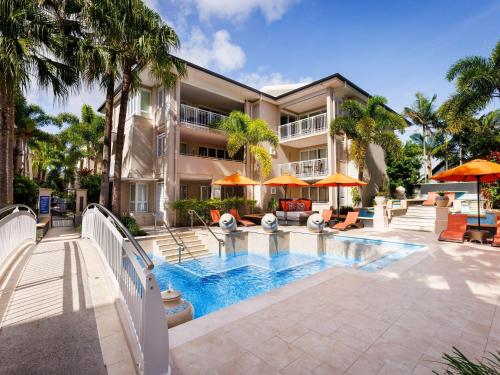 a swimming pool in front of a building at The Sebel Noosa in Noosa Heads