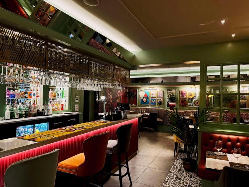 un restaurante con un bar con paredes rojas y verdes en Best Western New Kent Hotel, en Newcastle