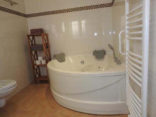 a white bath tub in a bathroom with a toilet at Ferienwohnungen am Hauptplatz in Pirna