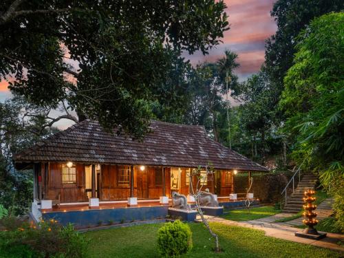 a small house in the middle of a yard at Ragamaya Resort & Spa Munnar in Munnar