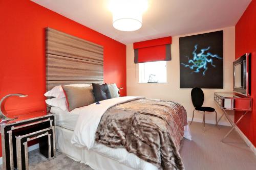 1 dormitorio con paredes rojas, 1 cama y TV en Trendy apartment a short drive from Aberdeen City, en Aberdeen