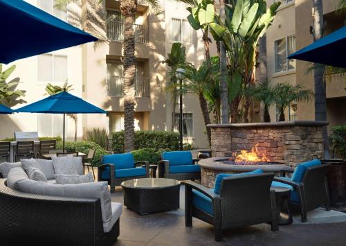 un patio avec des chaises et un foyer extérieur en face d'un bâtiment dans l'établissement Hyatt House San Diego Sorrento Mesa, à Sorrento