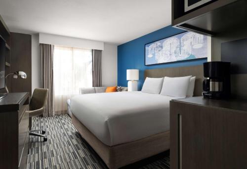 una habitación de hotel con una gran cama blanca y una ventana en Hyatt House San Diego Sorrento Mesa, en Sorrento