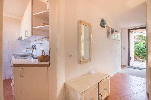 una pequeña cocina con lavabo y espejo en Cala Flores Gem - Sea View Lovely Apartment en Porto Cervo