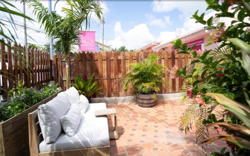 a patio with a white couch and a wooden fence at The Monteray Hotel in Christ Church