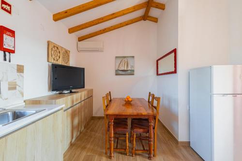 a kitchen with a small table and a refrigerator at Monte do Cerro in Porto Covo