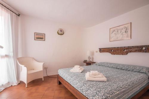 1 dormitorio con 1 cama con 2 toallas en Cala Flores Gem - Sea View Lovely Apartment en Porto Cervo