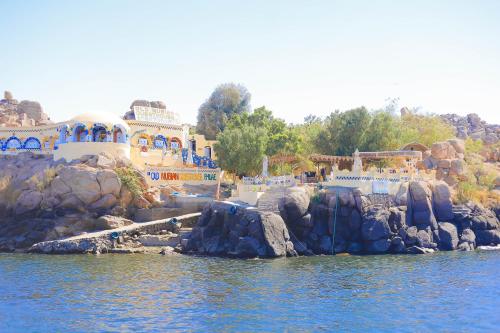 a resort on the water with a bunch of buildings at Old Nubian guest house in Aswan