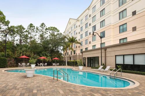 a swimming pool in front of a building at Hilton Garden Inn Palm Coast Town Center in Palm Coast