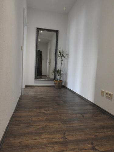an empty room with a mirror and a wooden floor at Ferienwohnungen am Hauptplatz in Pirna