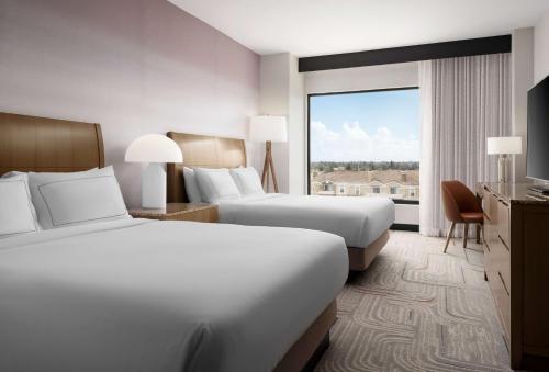 Cette chambre comprend deux lits et une grande fenêtre. dans l'établissement DoubleTree by Hilton Irvine Spectrum, à Irvine