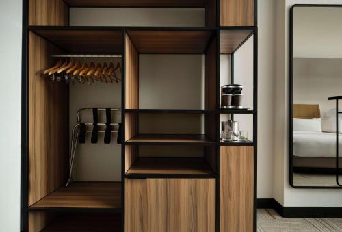 a closet with wooden shelves and a mirror at DoubleTree by Hilton Irvine Spectrum in Irvine