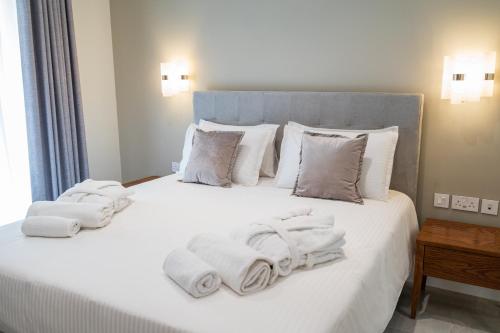 a bedroom with a white bed with towels on it at L-Eremita Boutique Hotel in Qala