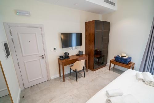 a bedroom with a desk and a tv and a bed at L-Eremita Boutique Hotel in Qala