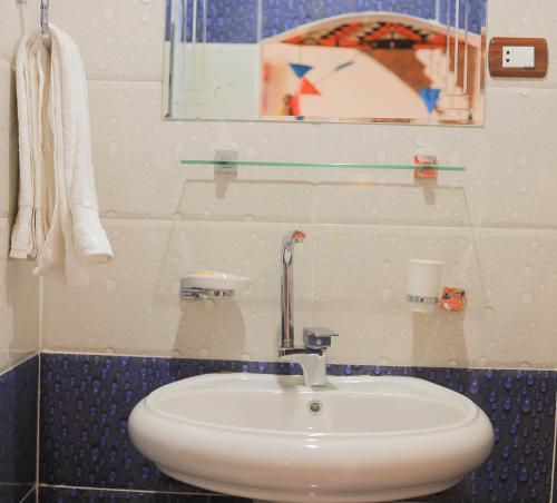 a bathroom with a white sink and a mirror at Old Nubian guest house in Aswan