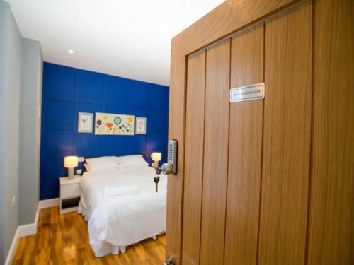 een slaapkamer met een bed en een blauwe muur bij Pass the Keys Stonebow room at Tavmar Apartments in Lincoln