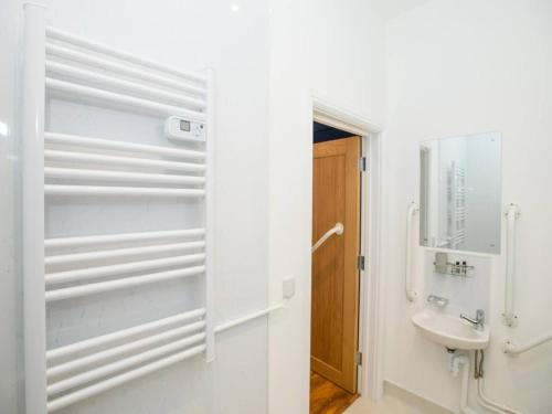 een witte badkamer met een wastafel en een spiegel bij Pass the Keys Stonebow room at Tavmar Apartments in Lincoln
