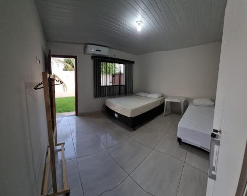a room with two beds and a window at Recanto das Araras, Transcendental in Bonito