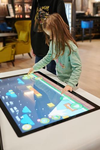 a little girl playing a game on an interactive table at Crona SPA Karpaty in Skhidnitsa