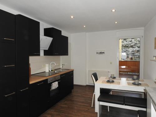 a kitchen with black cabinets and a white counter top at Ferienwohnungen am Hauptplatz in Pirna