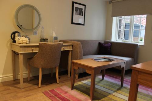 a living room with a desk and a couch and a mirror at Judge's Lodging in York
