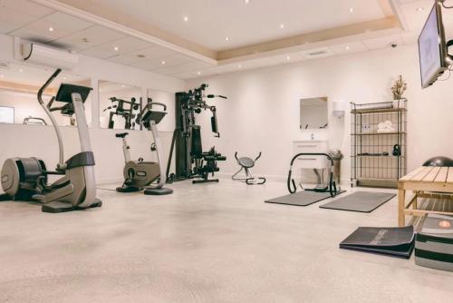een fitnessruimte met fitnessapparatuur in een witte kamer bij Hotel Alkmaar in Alkmaar