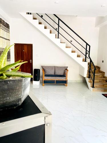 a living room with a staircase and a couch at Royal Homes and Wellness Center in Kurunegala